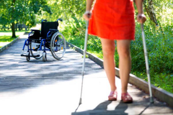 person in crutches with wheelchair